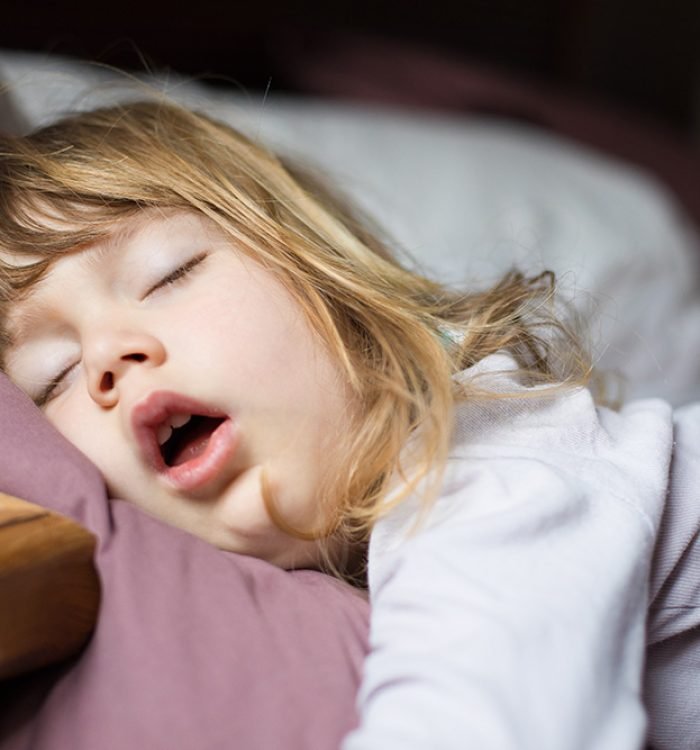 funny face expression with open mouth of blonde caucasian three years old child,  sleeping on  king bed
