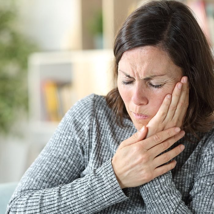 Middle age woman suffering toothache at home