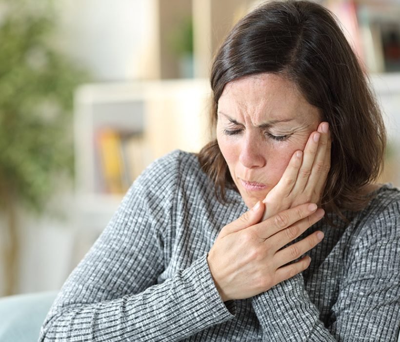 Middle age woman suffering toothache at home